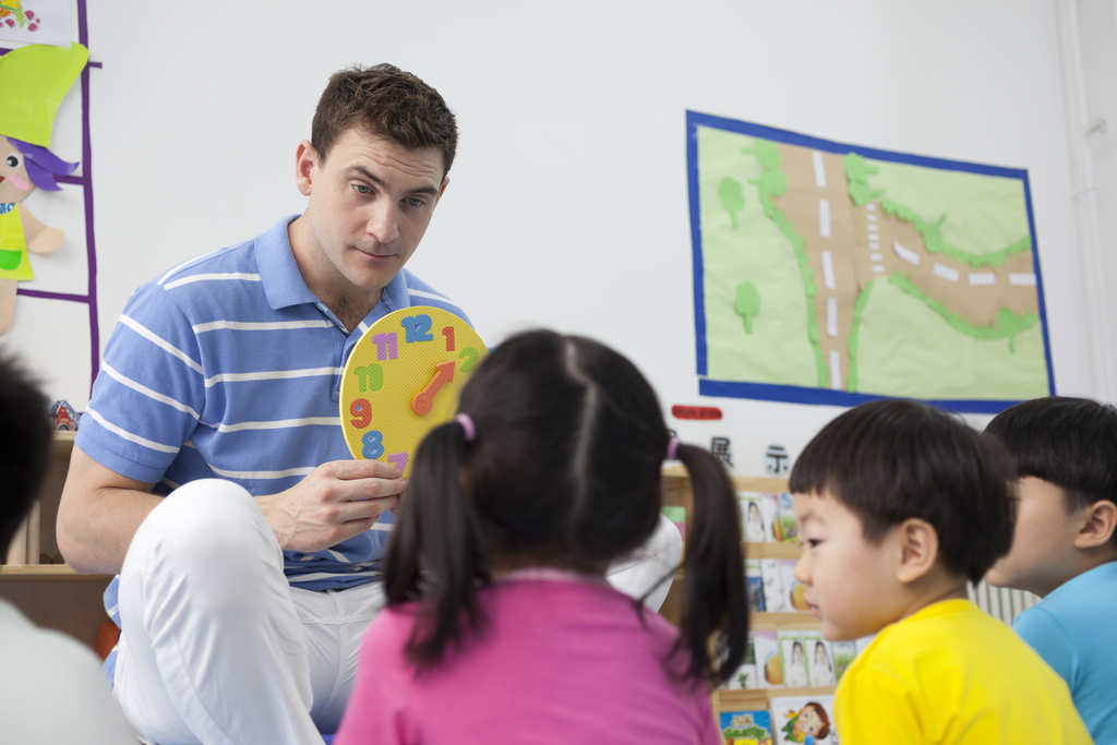 幼儿园外教男老师教小朋友们认识时钟图片