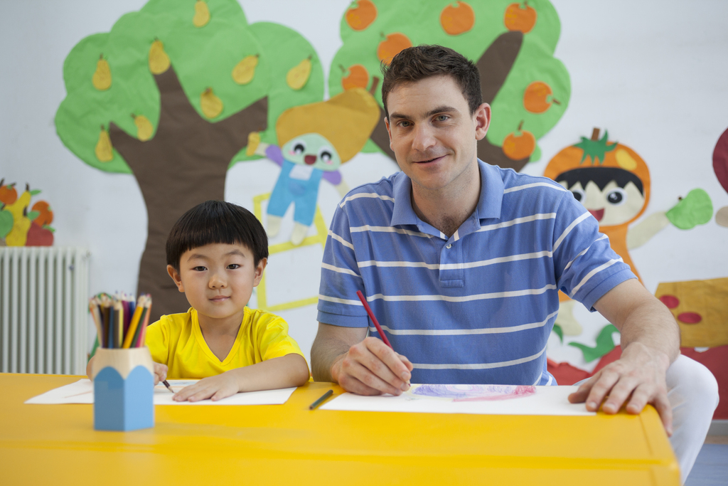 幼儿园外教男老师指导小朋友画画
