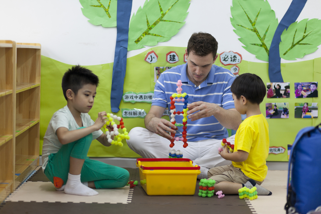 幼儿园外教男老师和儿童一起玩图片