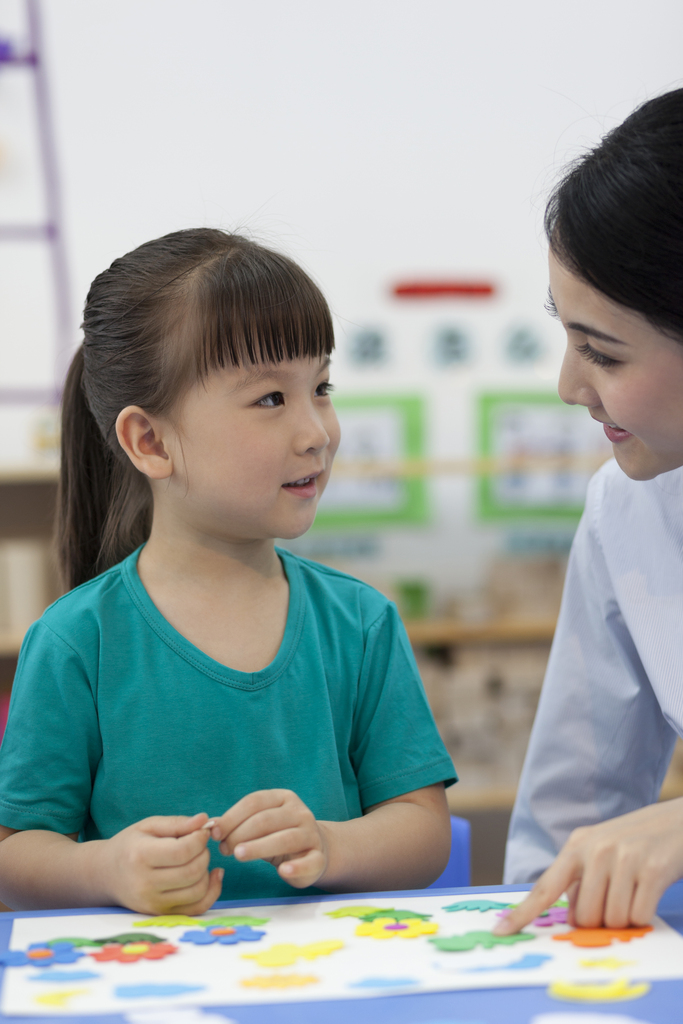 幼儿园女老师辅导儿童做手工图片