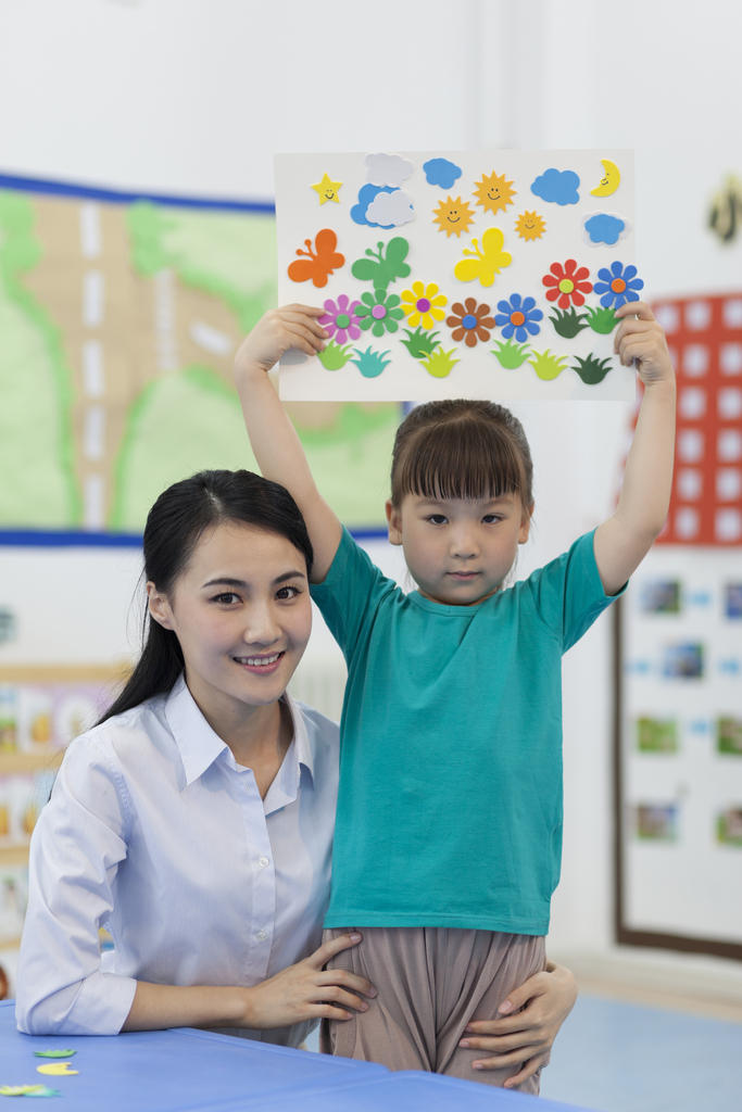 幼儿园女老师和儿童展示手工儿童画图片