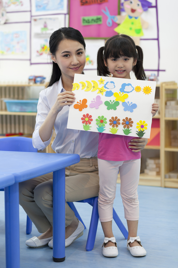 幼儿园女老师和儿童展示手工儿童画图片