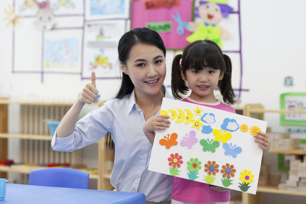 幼儿园女老师和儿童展示手工儿童画图片