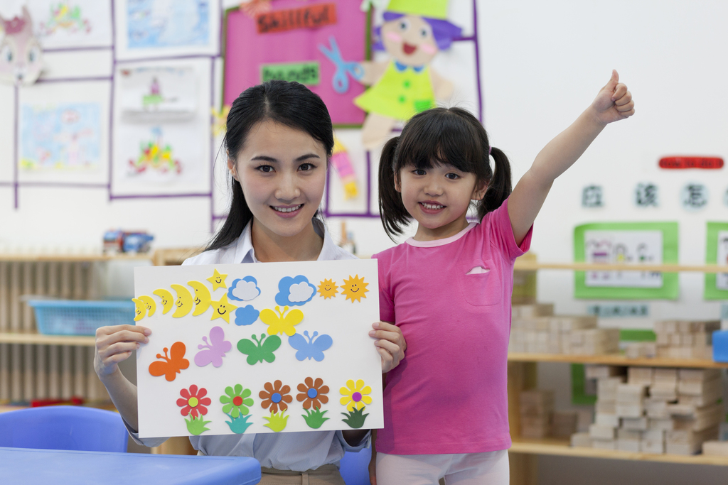 幼儿园女老师和儿童展示手工儿童画