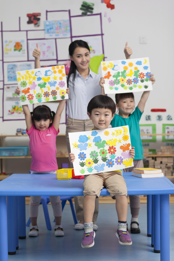 幼儿园女老师和儿童展示手工儿童画图片