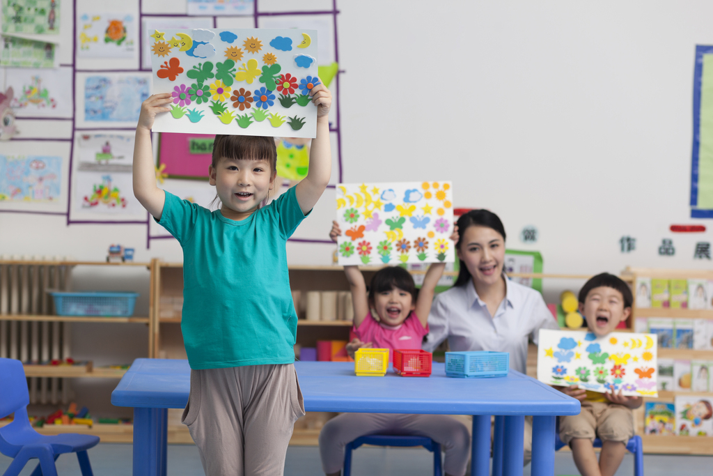 幼儿园女老师和儿童展示手工儿童画图片