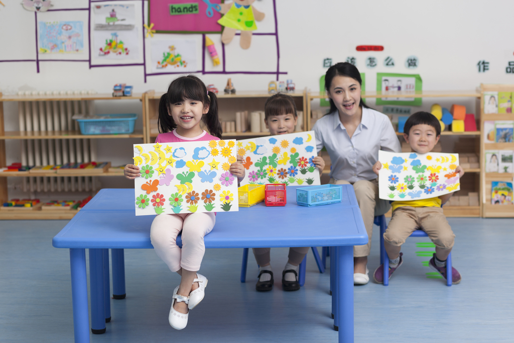 幼儿园女老师和儿童展示手工儿童画图片