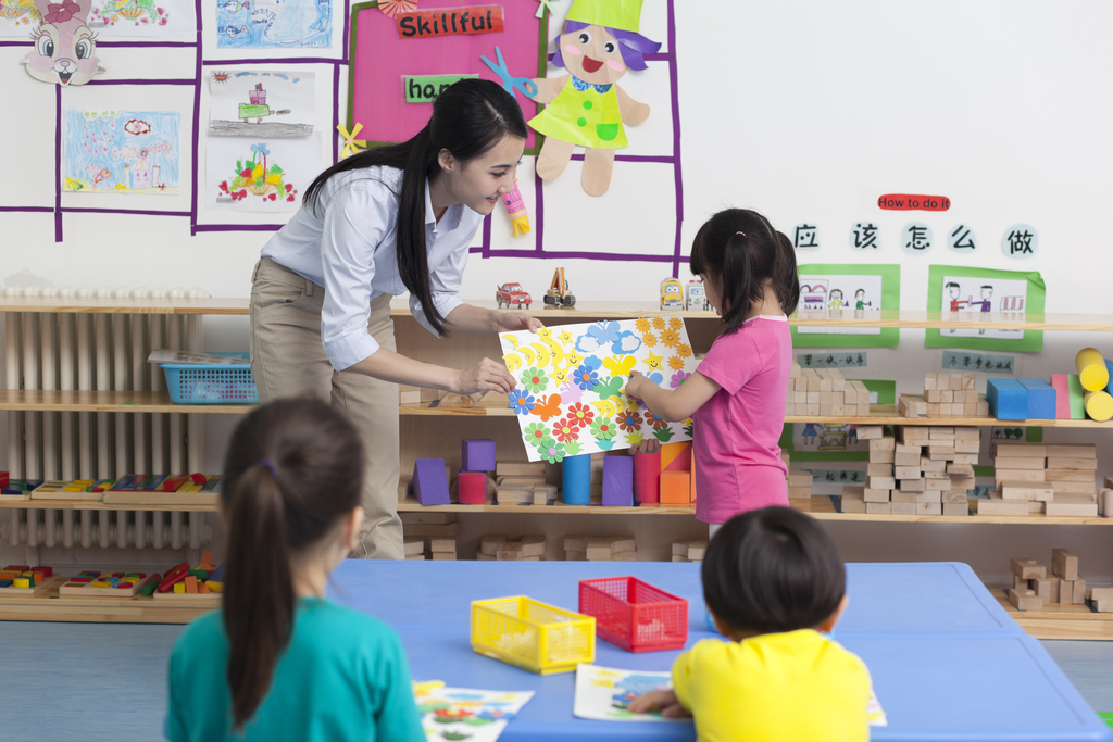 幼儿园女老师和儿童展示手工儿童画图片