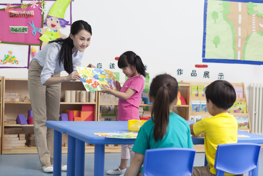 幼儿园女老师和儿童展示手工儿童画图片