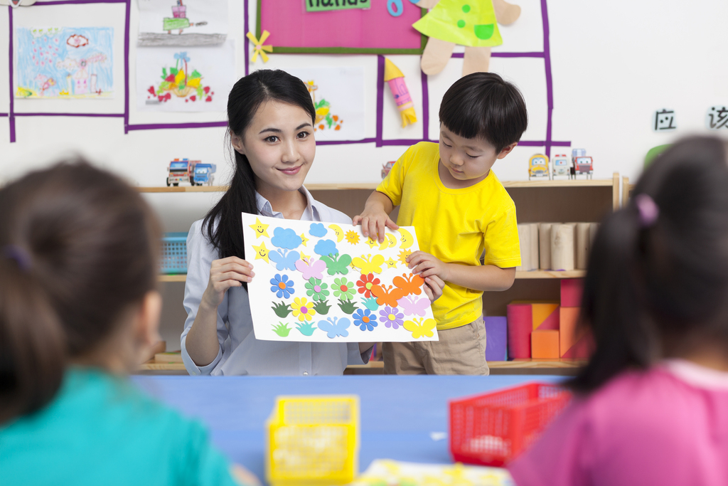 幼儿园女老师和儿童展示手工儿童画图片