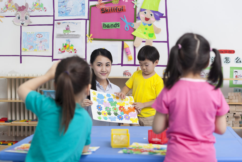 幼儿园女老师和儿童展示手工儿童画