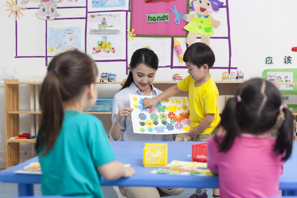 幼儿园女老师和儿童展示手工儿童画