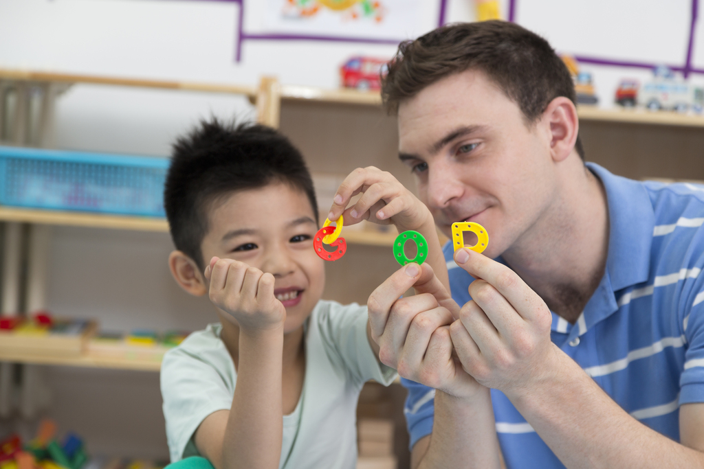 幼儿园外教男老师和儿童一起玩字母游戏图片