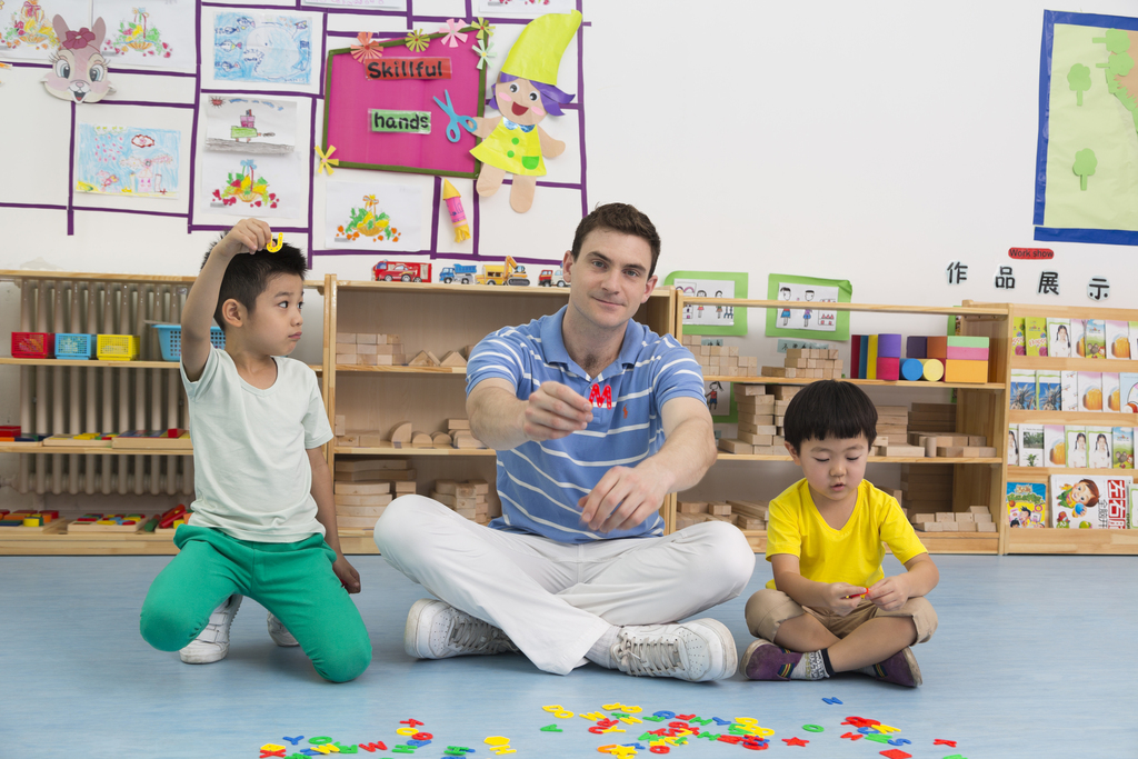 幼儿园外教男老师和儿童一起玩字母游戏图片