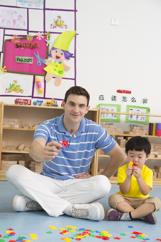 幼儿园外教男老师和儿童一起玩字母游戏