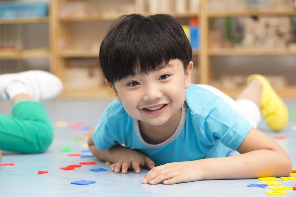 幼儿园儿童趴地板上玩玩具