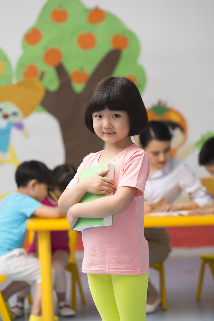 幼儿园儿童抱着书本站立微笑图片