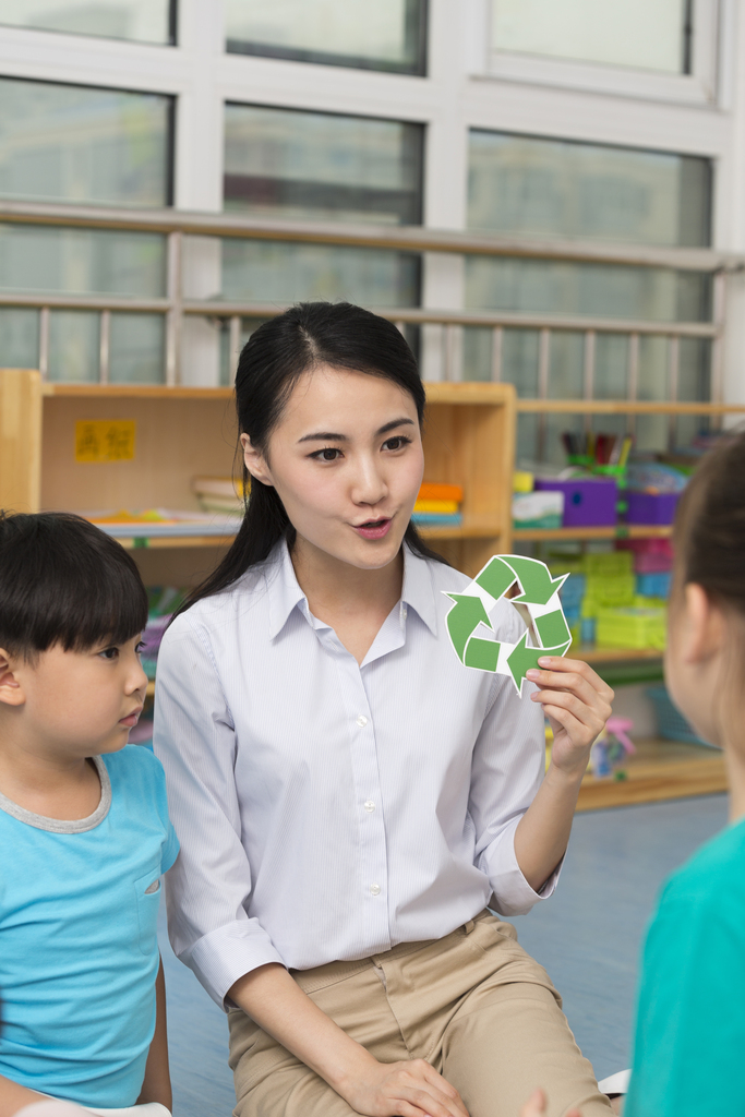 幼儿园女老师拿着环保标志图片