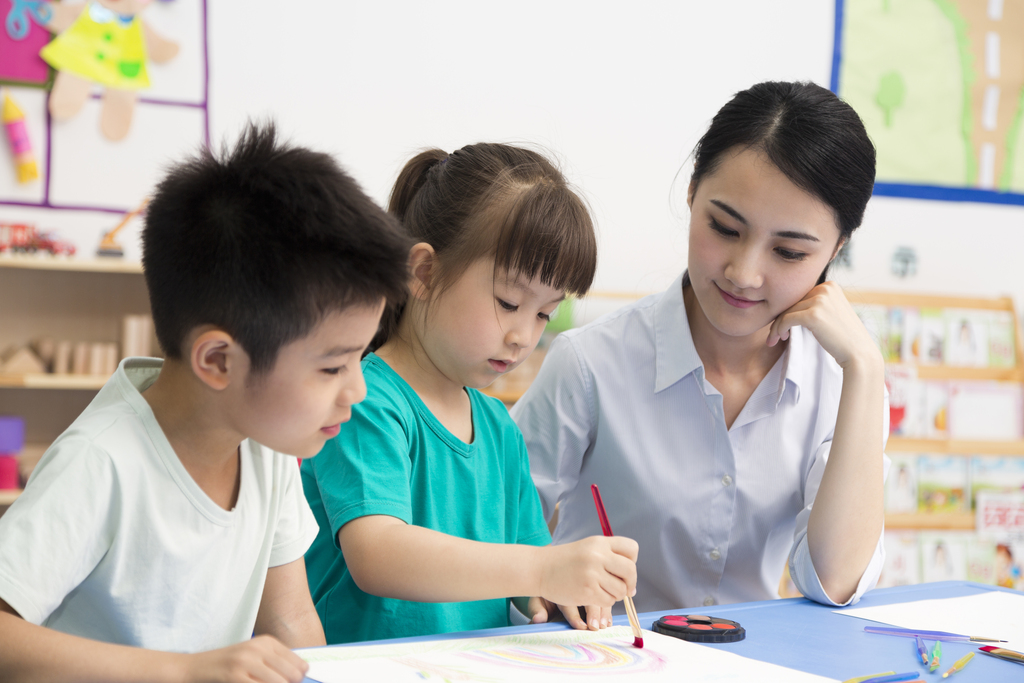 幼儿园女老师辅导儿童画画