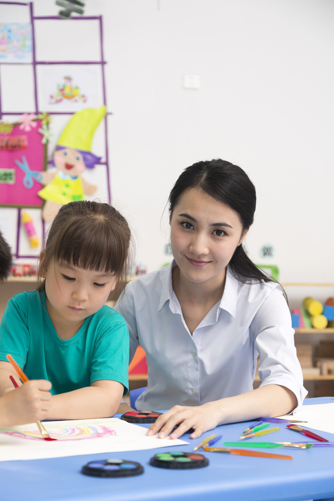 幼儿园女老师辅导儿童画画图片