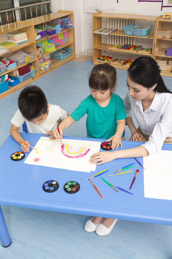 幼儿园女老师辅导儿童画画图片