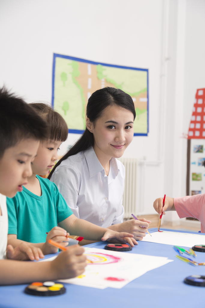 幼儿园女老师辅导儿童画画图片