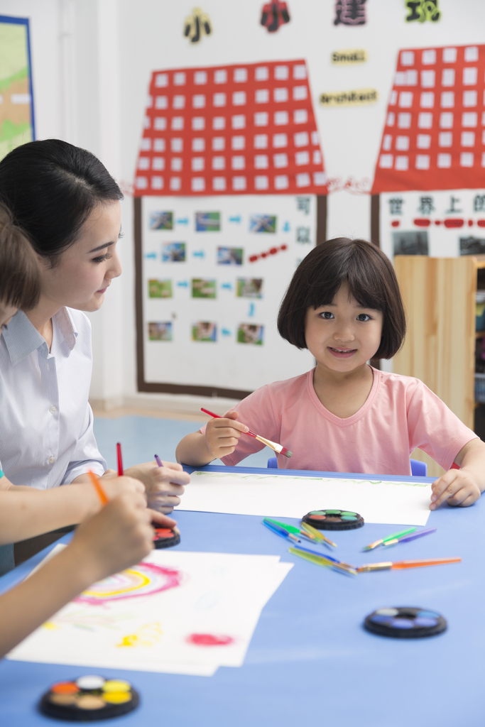 幼儿园女老师辅导儿童画画图片