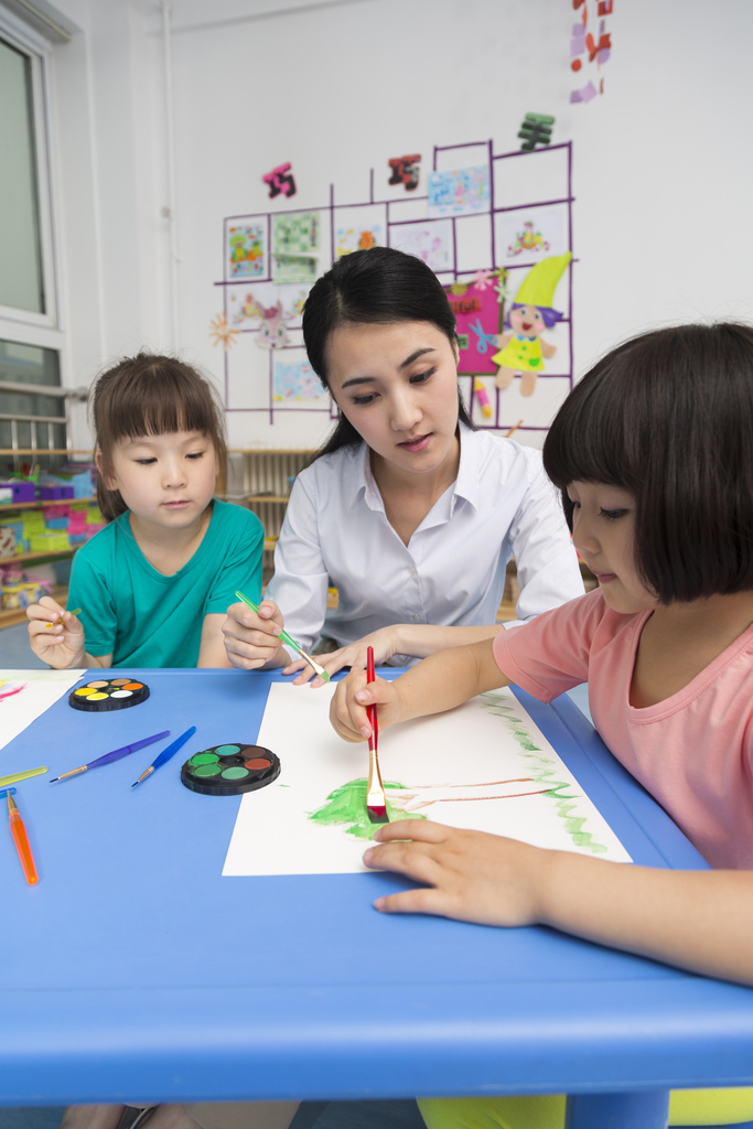 幼儿园女老师辅导儿童画画图片