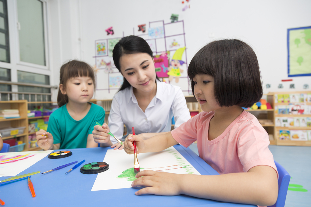 幼儿园女老师辅导儿童画画