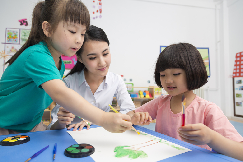 幼儿园女老师辅导儿童画画