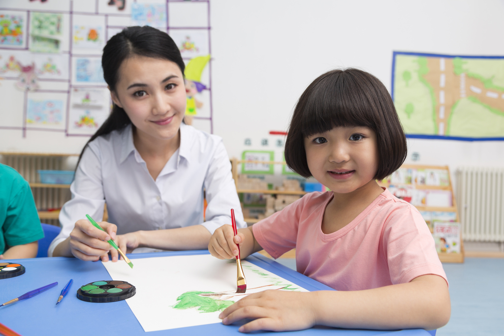 幼儿园女老师辅导儿童画画图片