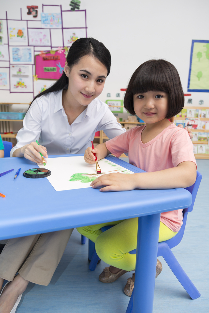 幼儿园女老师辅导儿童画画图片