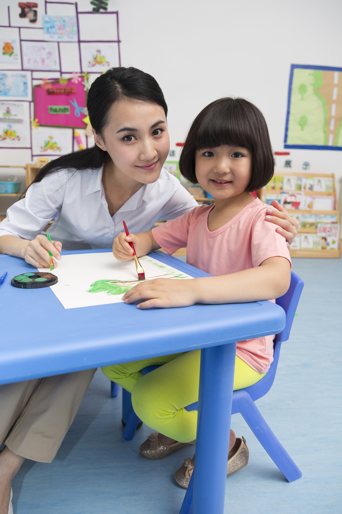 幼儿园女老师辅导儿童画画图片