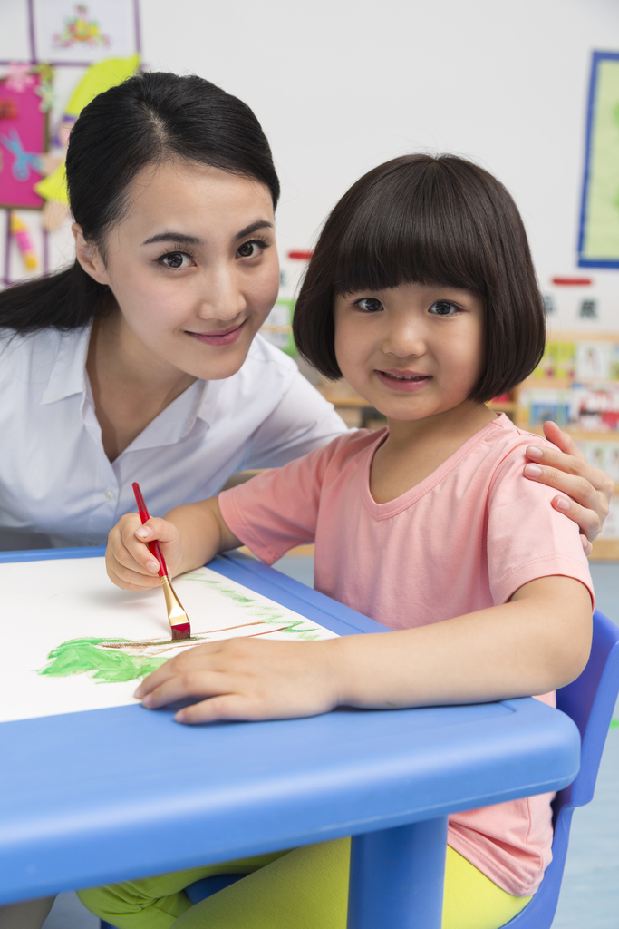 幼儿园女老师辅导儿童画画图片