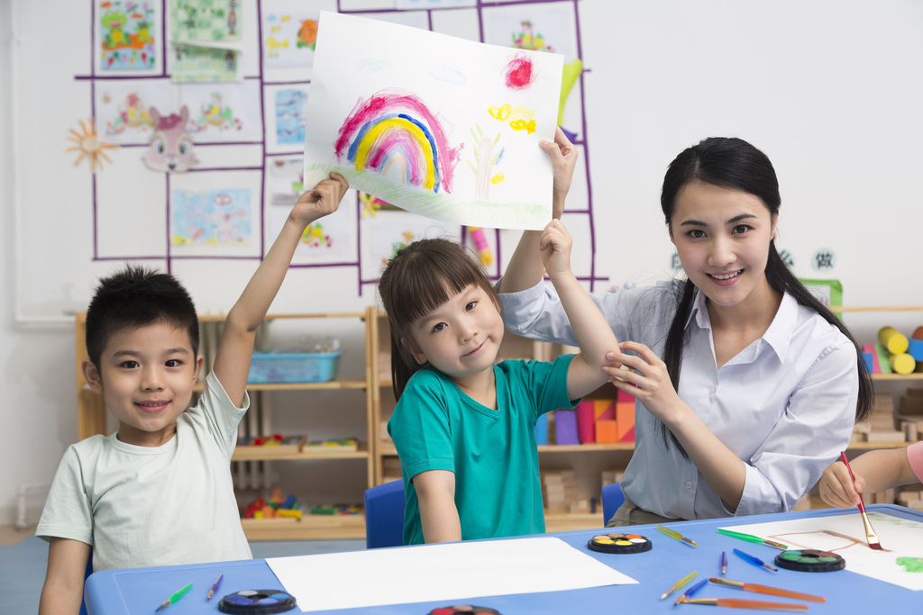 幼儿园女老师和儿童展示绘画作品图片