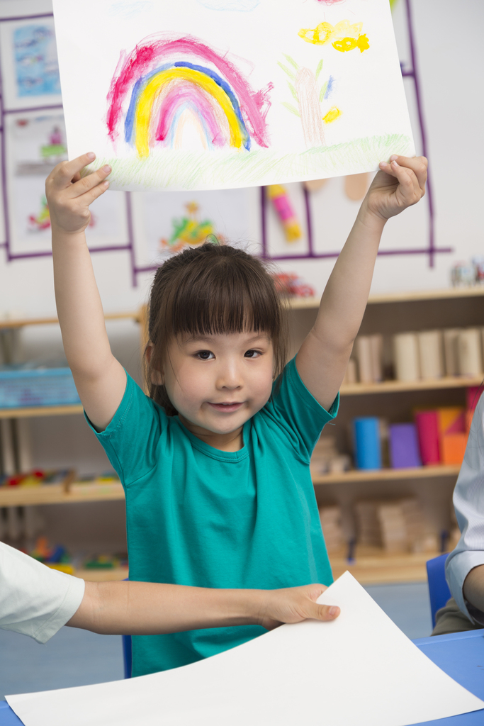 幼儿园女老师和儿童展示绘画作品