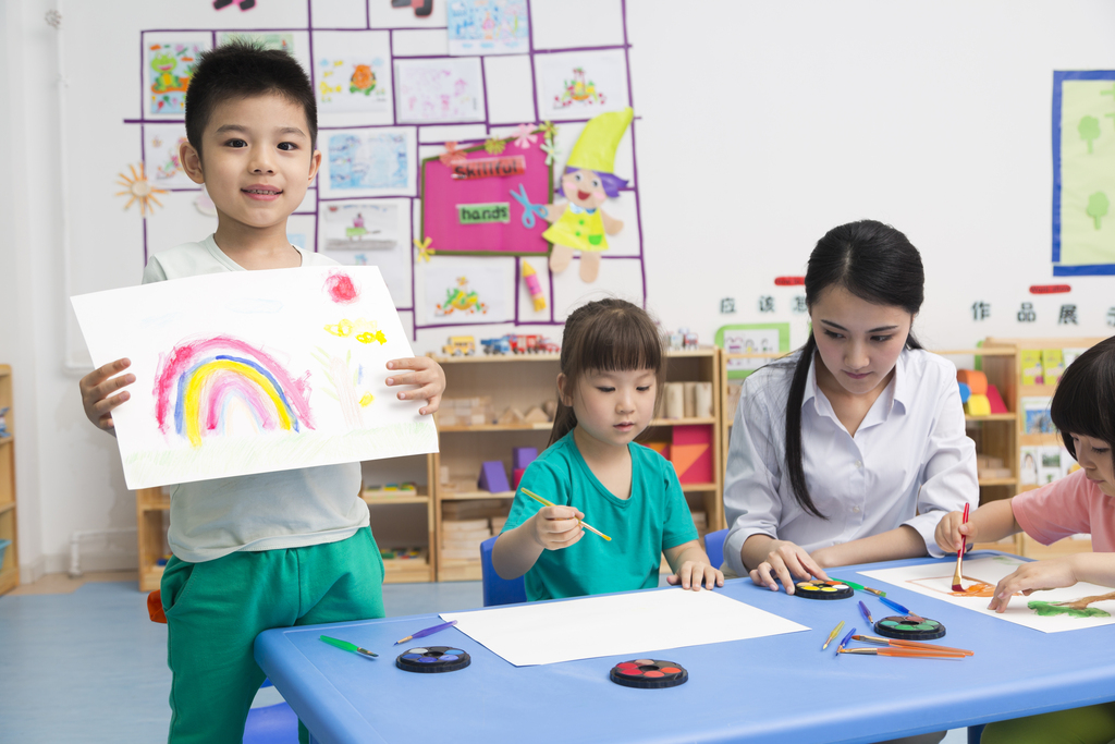 幼儿园女老师和儿童展示绘画作品图片