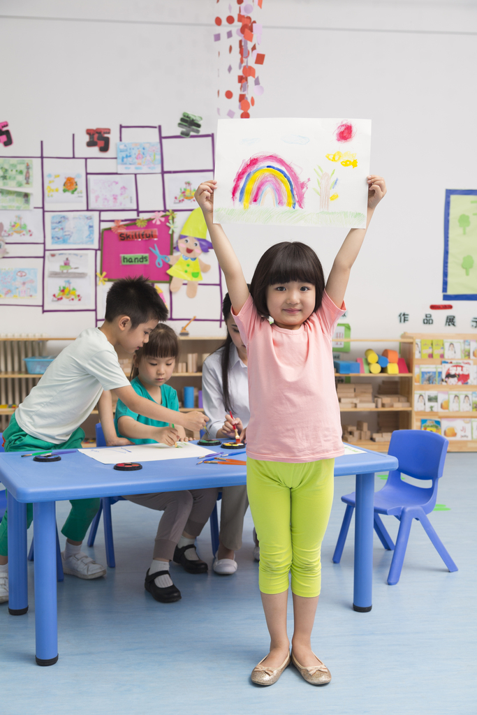 幼儿园女老师和儿童展示绘画作品图片