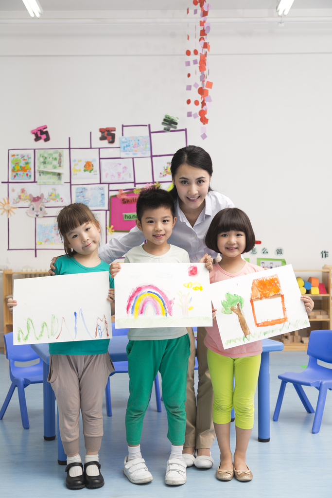 幼儿园女老师和儿童展示绘画作品图片