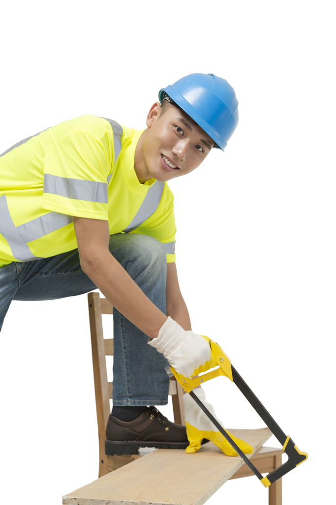 年轻的男建筑工人在锯木板图片