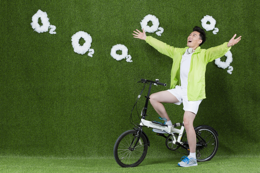 草地创意男青年骑自行车图片