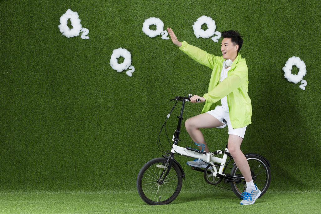 草地创意男青年骑自行车图片