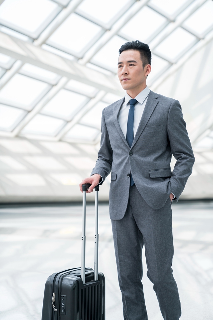 商务男士在机场,提着行李