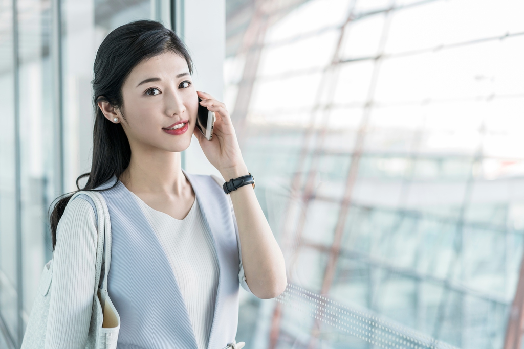 年轻商务女士在机场打电话 图片