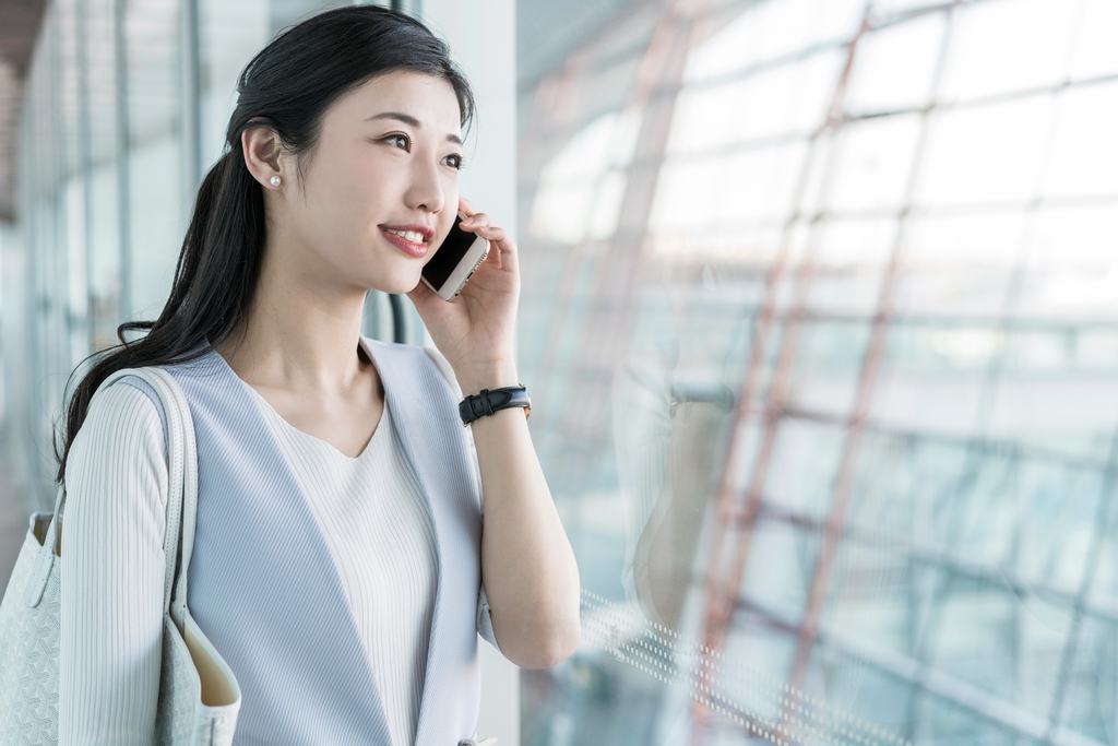 年轻商务女士在机场打电话 
