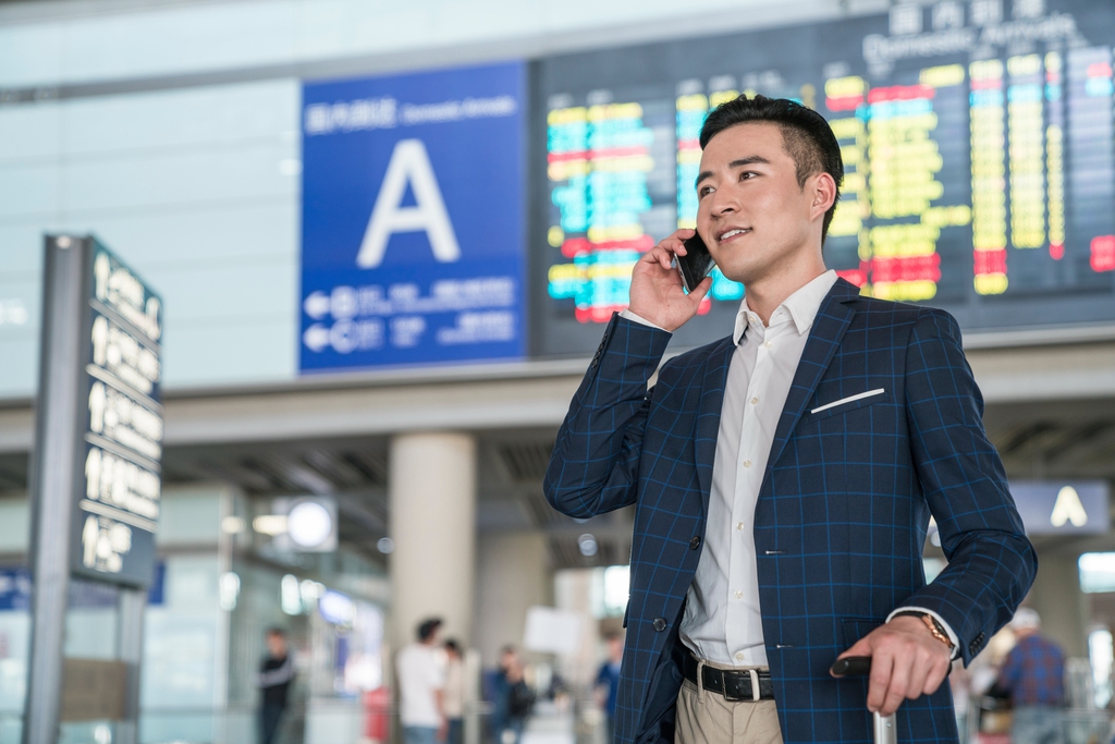 年轻商务男士在机场打电话 图片