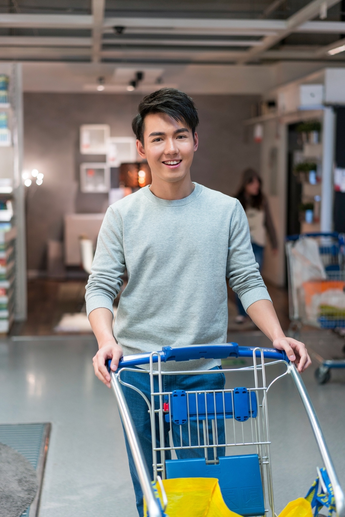 年轻男子手推购物车图片