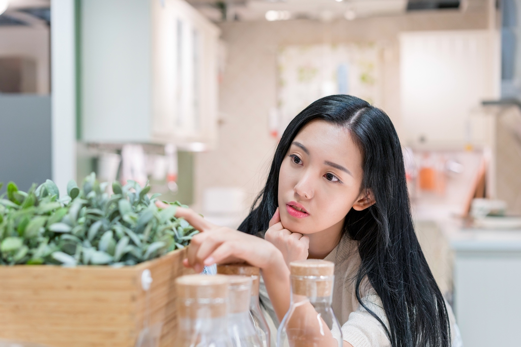 年轻女子欣赏花花草草图片