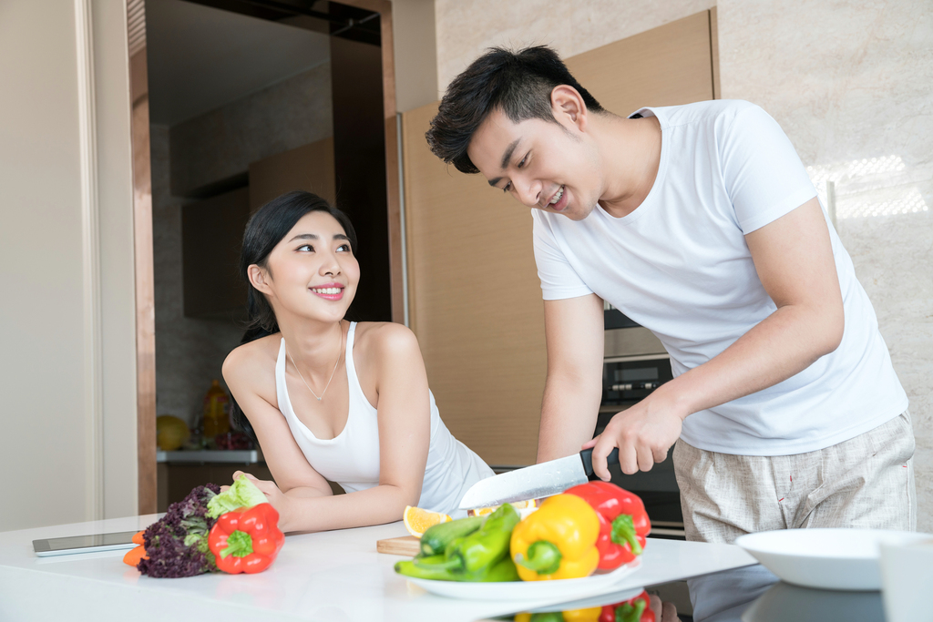 年轻情侣在厨房做饭图片