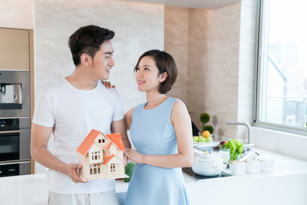 快乐的年轻情侣在厨房手拿模型图片